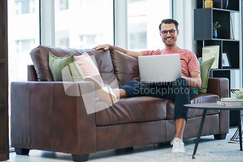 Image of Social media is a real popularity booster for your brand. a young man using a laptop while relaxing on a sofa.