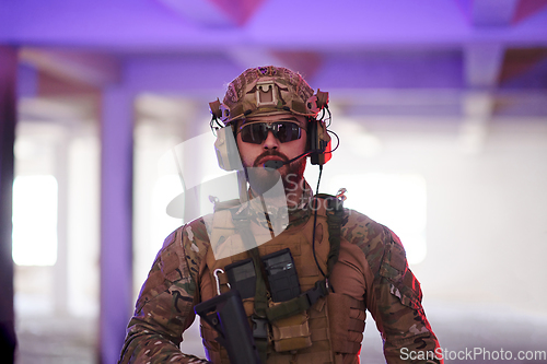 Image of A professional soldier undertakes a perilous mission in an abandoned building illuminated by neon blue and purple lights