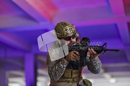 Image of A professional soldier undertakes a perilous mission in an abandoned building illuminated by neon blue and purple lights