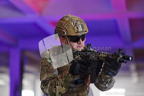 Image of A professional soldier undertakes a perilous mission in an abandoned building illuminated by neon blue and purple lights