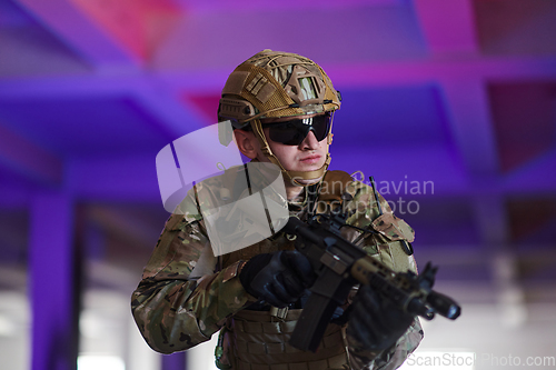 Image of A professional soldier undertakes a perilous mission in an abandoned building illuminated by neon blue and purple lights