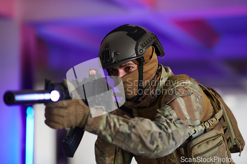 Image of A professional soldier undertakes a perilous mission in an abandoned building illuminated by neon blue and purple lights