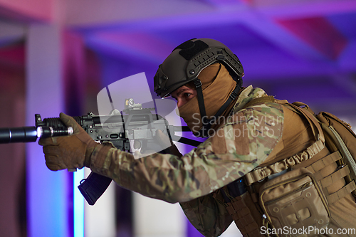 Image of A professional soldier undertakes a perilous mission in an abandoned building illuminated by neon blue and purple lights