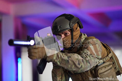 Image of A professional soldier undertakes a perilous mission in an abandoned building illuminated by neon blue and purple lights