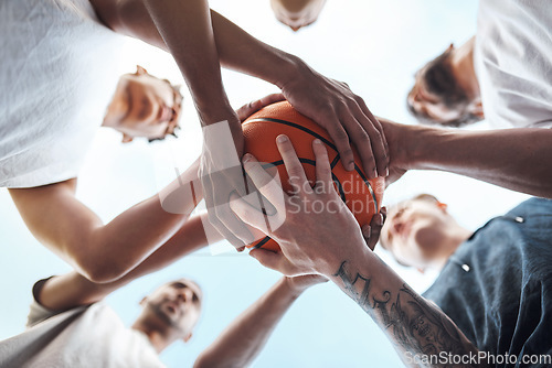 Image of One team, one dream. Closeup shot of a group of sporty young men huddled around a basketball on a sports court.