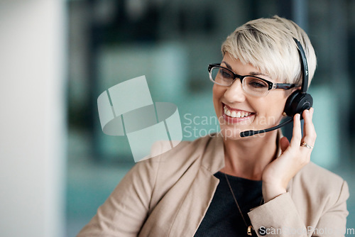 Image of The outcome of her calls are always successful. a young businesswoman wearing a headset while working in an office.