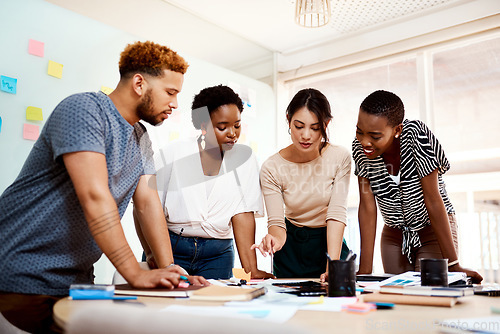 Image of Working on something new and different for their customers. a group of young creatives working together in an office.