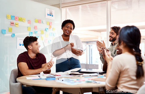 Image of Talent that shines brightly deserves to be recognised. a group of young creatives applauding a colleague during a meeting in an office.