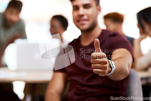 Image of Stay positive and you will prosper. Closeup shot of a young businessman showing thumbs up in an office.