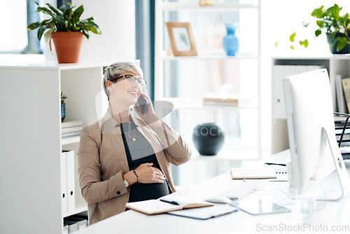 Image of Ill be out of the office soon. a pregnant businesswoman talking on a cellphone in an office.