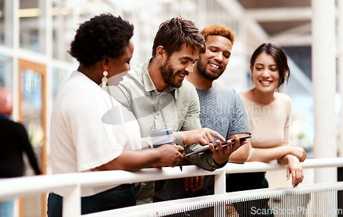 Image of Pushing the boundaries to reach greatness together. a group of young creatives using a digital tablet together in an office.