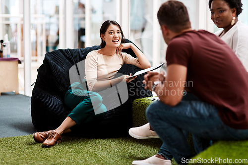 Image of Providing the right environment helps promote creativity in the workplace. a young businesswoman having a discussion with her colleagues while sitting on a beanbag in an office.