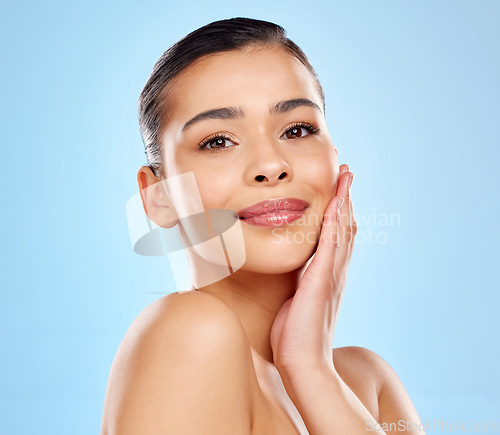 Image of Good skin takes time. Studio portrait of an attractive young woman posing against a blue background.