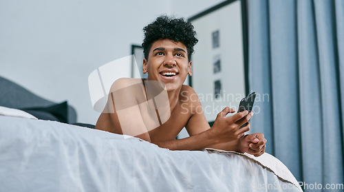 Image of Texting people you never thought youd text, welcome to lockdown. a young man relaxing on his bed and using a smartphone.