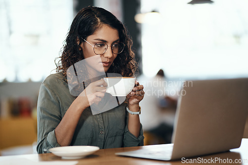 Image of Where work meets leisure. a young woman using a laptop and having coffee in a cafe.