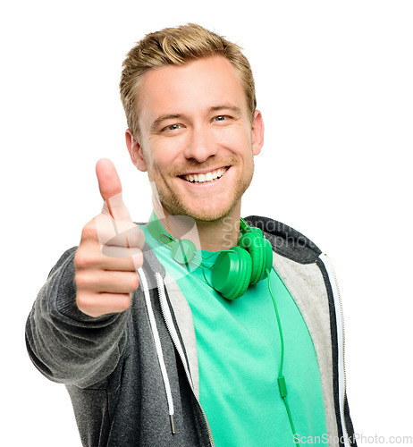 Image of Youre doing great. a handsome young man standing alone in the studio and showing a thumbs up.