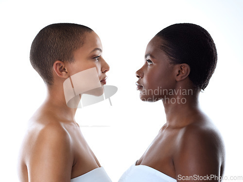 Image of I see a whole different world when I look into your eyes. Studio shot of two beautiful young women looking into each others eyes while standing against a white background.