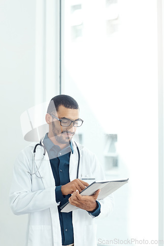 Image of Determining the cause of his patients condition. a young doctor using a digital tablet in a modern hospital.