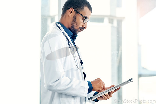 Image of Staying up to date with new surgical techniques. a young doctor using a digital tablet in a modern hospital.