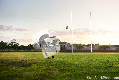 Image of I never quit trying. Full length shot of a handsome young sportsman kicking a rugby ball during an early morning training session.