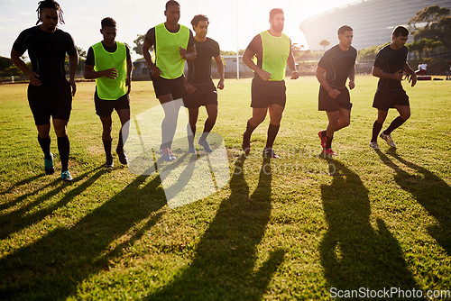 Image of Building up the momentum. Full length shot of a diverse group of sportsmen warming up before playing rugby during the day.