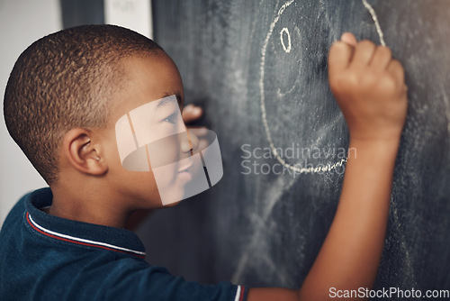 Image of The only limits are the limits of their imagination. a young boy writing on a blackboard at home.