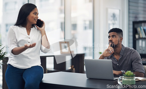 Image of Please keep your voice down, Im trying to work here. a young businessman gesturing for his colleague to be quiet in an office.