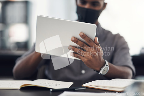 Image of Using the latest apps to boost workplace performance. Closeup shot of an unrecognisable businessman using a digital tablet in an office.