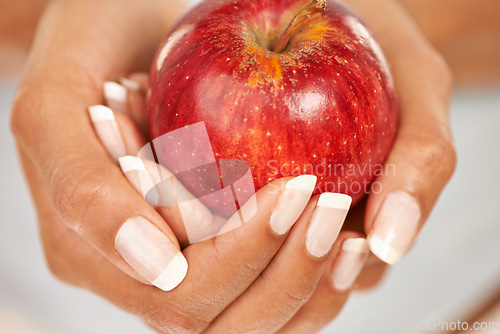 Image of Hands, apple or food with a person closeup for health, diet or nutrition in the kitchen of her home. Fruit, nutritionist and hunger with an adult eating fresh produce for a healthy weight loss snack