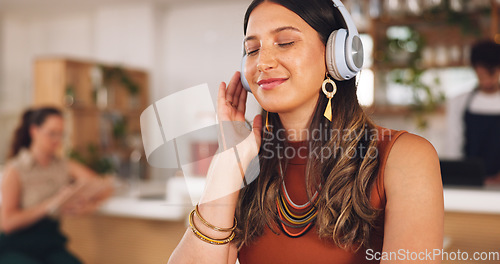 Image of Music, freelance and woman in coffee shop with headphones, connection and streaming with smile. Relax, technology and remote work, happy girl in cafe listening to audio, radio or motivation podcast.