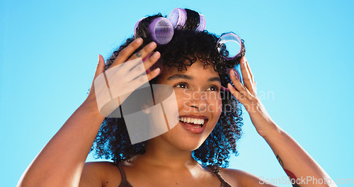 Image of Beauty, smile and woman with roller for hair in studio isolated on a blue background. Curlers, hairstyle and African model at hairdresser salon for natural wellness, cosmetics treatment and thinking