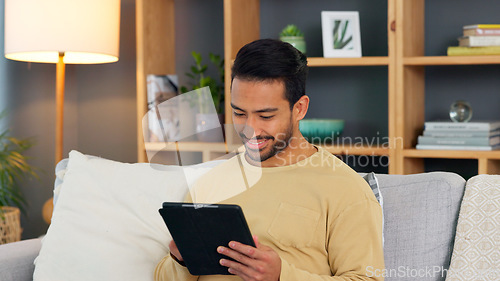 Image of Relax, smile and asian man with a tablet a sofa for social media, chat or streaming at home. Digital, app and Japanese male in a living room happy for gif, meme or web, post and online communication