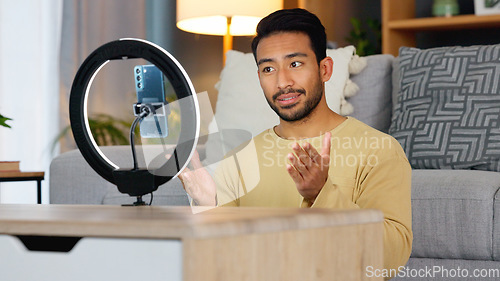 Image of Influencer man, phone and ring light for live stream, web chat or recording in home living room. Content creator guy, video call or vlogger on smartphone, contact or communication in lounge at house