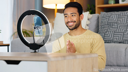 Image of Influencer man, phone and ring light for talk, live stream or web chat in home living room. Content creator guy, video call or vlogger on cellphone, contact or recording in lounge, house or apartment