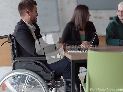 Image of Close up photo of a diverse group of business professionals, including an person with a disability, gathered at a modern office for a productive and inclusive meeting.