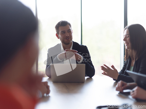 Image of A diverse group of business professionals gathered at a modern office for a productive and inclusive meeting