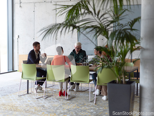 Image of A diverse group of business professionals gathered at a modern office for a productive and inclusive meeting