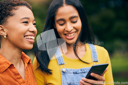 Image of Phone, happy and women in park for social media, online post and laughing at meme outdoors. Friendship, mobile app and female people smile on smartphone for bonding, holiday and relaxing in nature