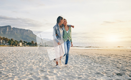 Image of Love, beach and lesbian couple hug while walking together on sand, sunset holiday adventure or date. Lgbt women, bonding and relax on ocean vacation with romance, pride and happy travel in nature.