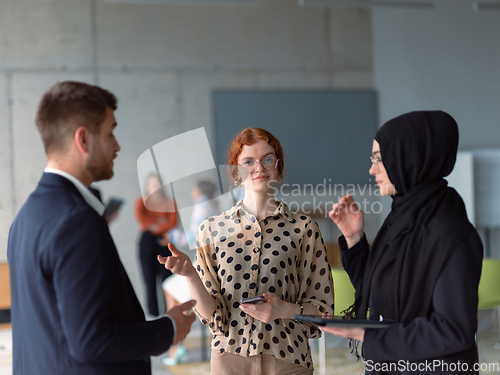 Image of A group of young business entrepreneurs engages in a lively discussion within the office, exemplifying the spirit of teamwork, innovation, and ambition in pursuit of success.