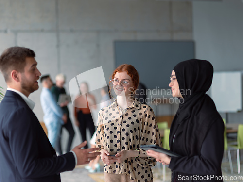 Image of A group of young business entrepreneurs engages in a lively discussion within the office, exemplifying the spirit of teamwork, innovation, and ambition in pursuit of success.