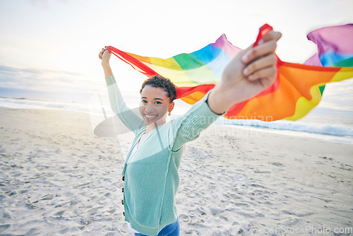 Image of Woman, beach and rainbow pride flag in portrait with smile, wind and waves for lgbtq, inclusion and equality. African girl, fabric or cloth for human rights, lesbian sexuality and happy on vacation