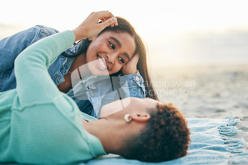 Image of Love, beach and lesbian couple lying on blanket together, embrace on sand and sunset holiday adventure. Lgbt women, bonding and relax on ocean vacation with romance, pride and happy picnic in nature.