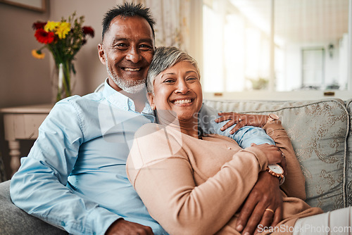 Image of Portrait, smile and senior couple in home living room on sofa for bonding together. Face, happy and elderly man and Indian woman on couch in lounge for quality time, care and relax for love in house