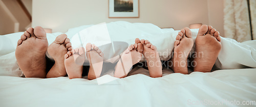 Image of Sleeping, feet and family in bed relax, peaceful and enjoying. a nap in their home together. Foot, sleep and children resting with in parents in a bedroom with love, safety and or vacation freedom