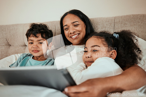 Image of Mother watching a movie on a tablet with her children in the bed to relax, rest and bond. Happy, smile and young mom streaming a show or video on social media on digital technology with kids at home.