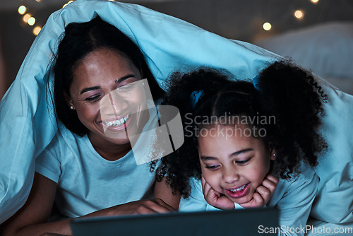 Image of Mom, child and tablet with blanket in bedroom at night to play games, social media and reading ebook. Happy mother, girl and kid relax with digital technology, watching cartoon or movies in dark fort