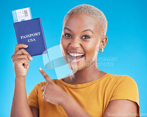 Image of Black woman, pointing at passport and plane ticket, excited about travel to USA in portrait on blue background. Adventure, boarding pass and documents for journey, female person is happy in studio