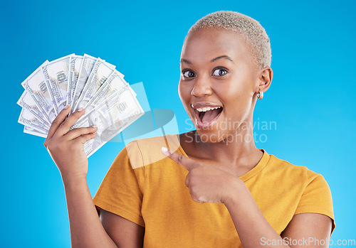 Image of Black woman, pointing at cash fan and surprise with finance, payment and lottery win isolated on blue background. Female person with wow face, money and financial freedom, dollar bills in a studio