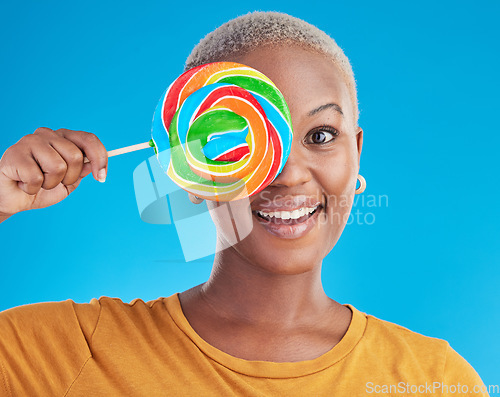 Image of Portrait, cover and black woman with a lollipop, candy and happiness on a blue studio background. Face, happy female person and African model with sugar treats, confectionary and cheerful girl